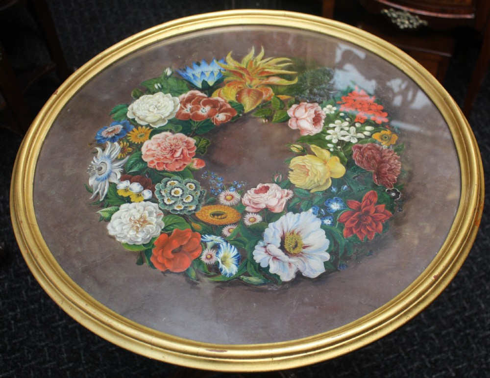 A Victorian circular occasional table featuring a hand-painted floral wreath top enclosed in a gold moulding, supported by a carved wooden pedestal and tripod scroll legs. View III
