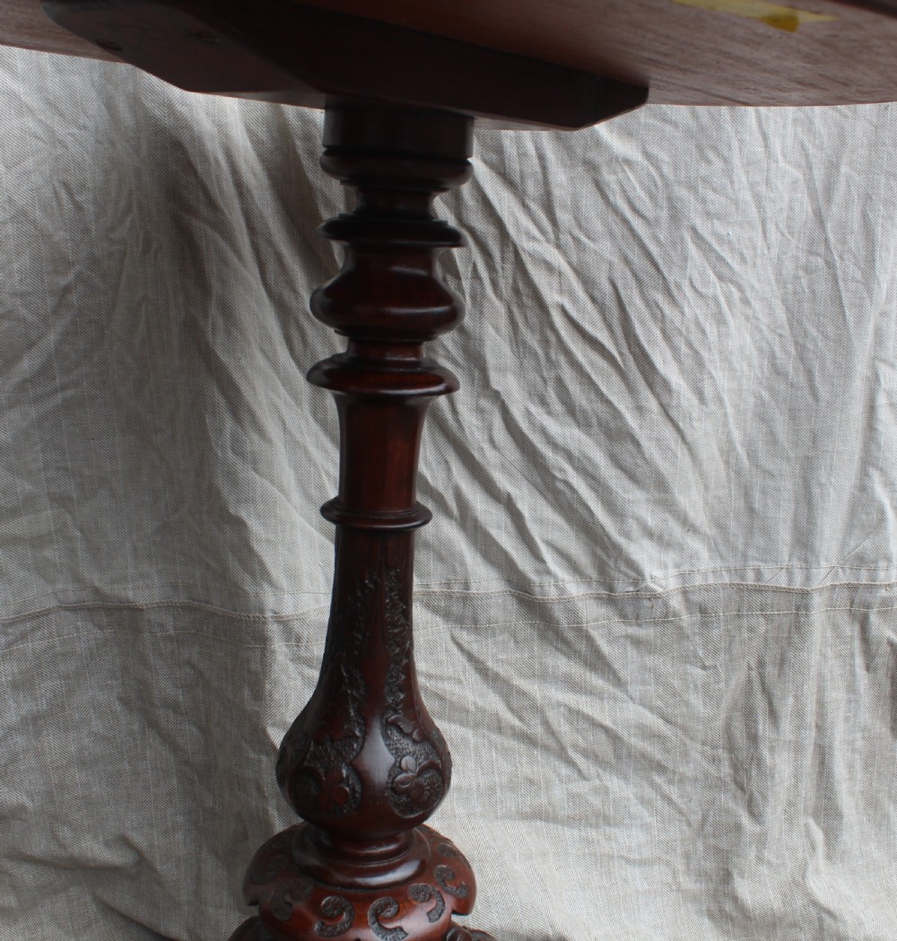 A circular antique wine table with a light parquetry inlaid top featuring a floral central motif on a carved dark mahogany tripod pedestal. View IV