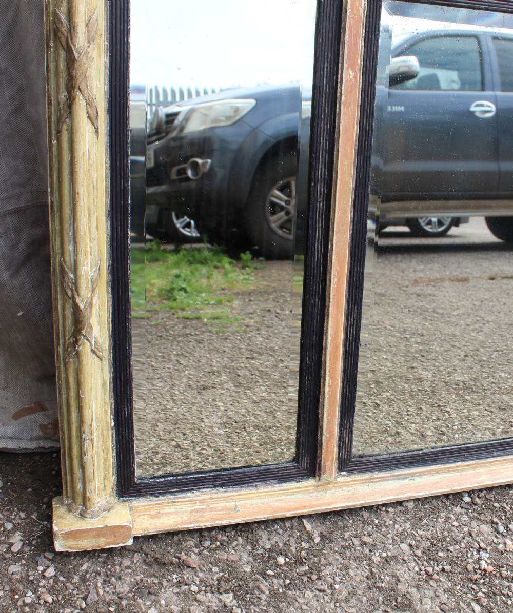 A wide horizontal antique overmantel mirror featuring a distressed cream painted finish, carved neoclassical urn motifs, and three distinct mirror panels. View III