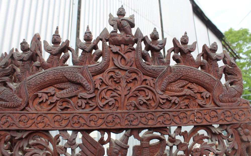 A three-panel dark wood folding screen featuring intricate hand-carved openwork lattice, floral scrolls, mythological figures, and a decorative crest. View VI