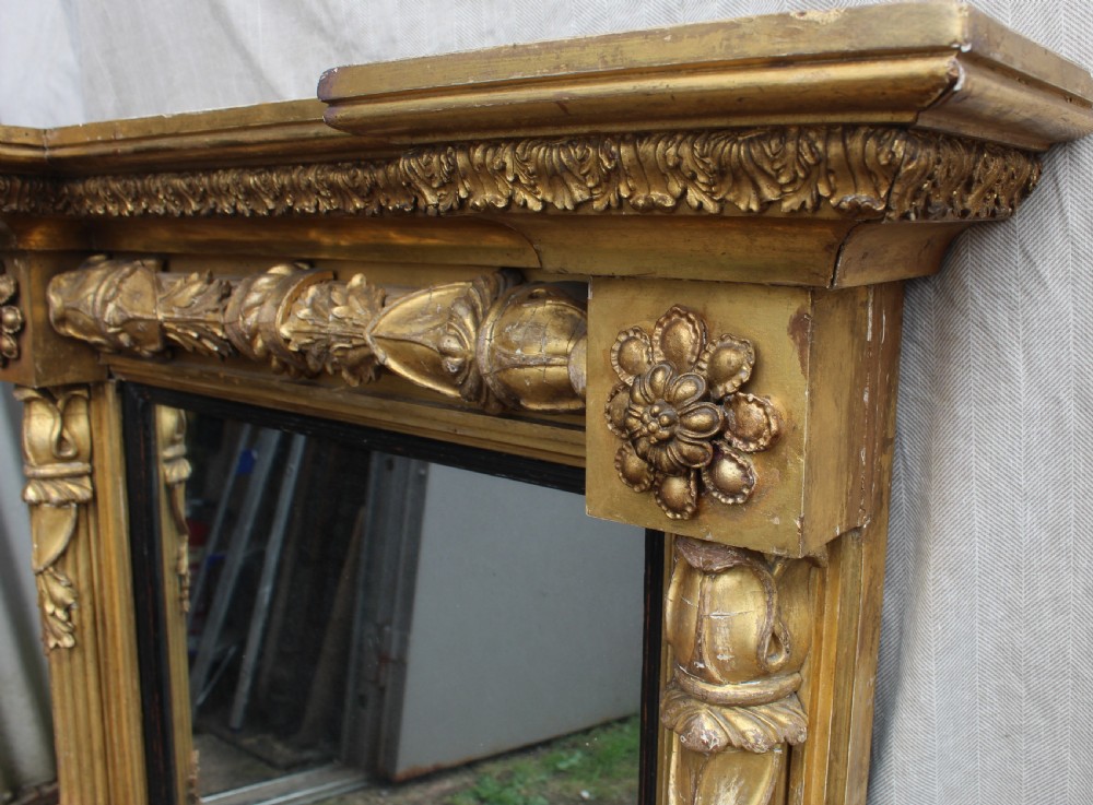 A rectangular antique giltwood pier mirror with fluted side columns, rosette medallions, and a stepped breakfront cornice. View II