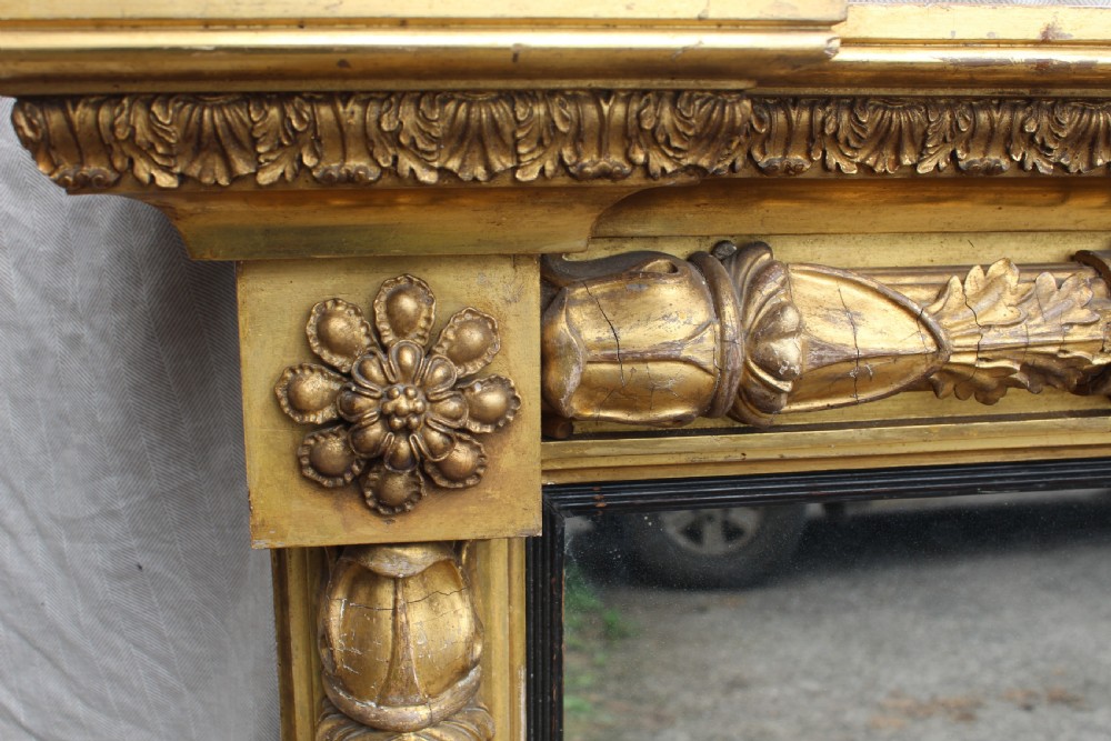 A rectangular antique giltwood pier mirror with fluted side columns, rosette medallions, and a stepped breakfront cornice. View VI