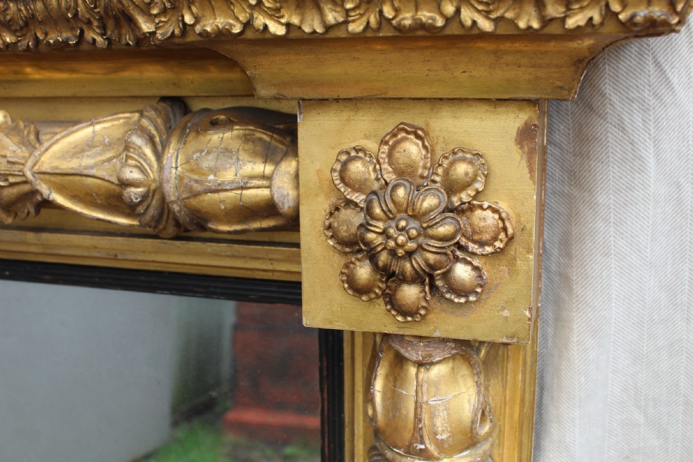 A rectangular antique giltwood pier mirror with fluted side columns, rosette medallions, and a stepped breakfront cornice. View VIII