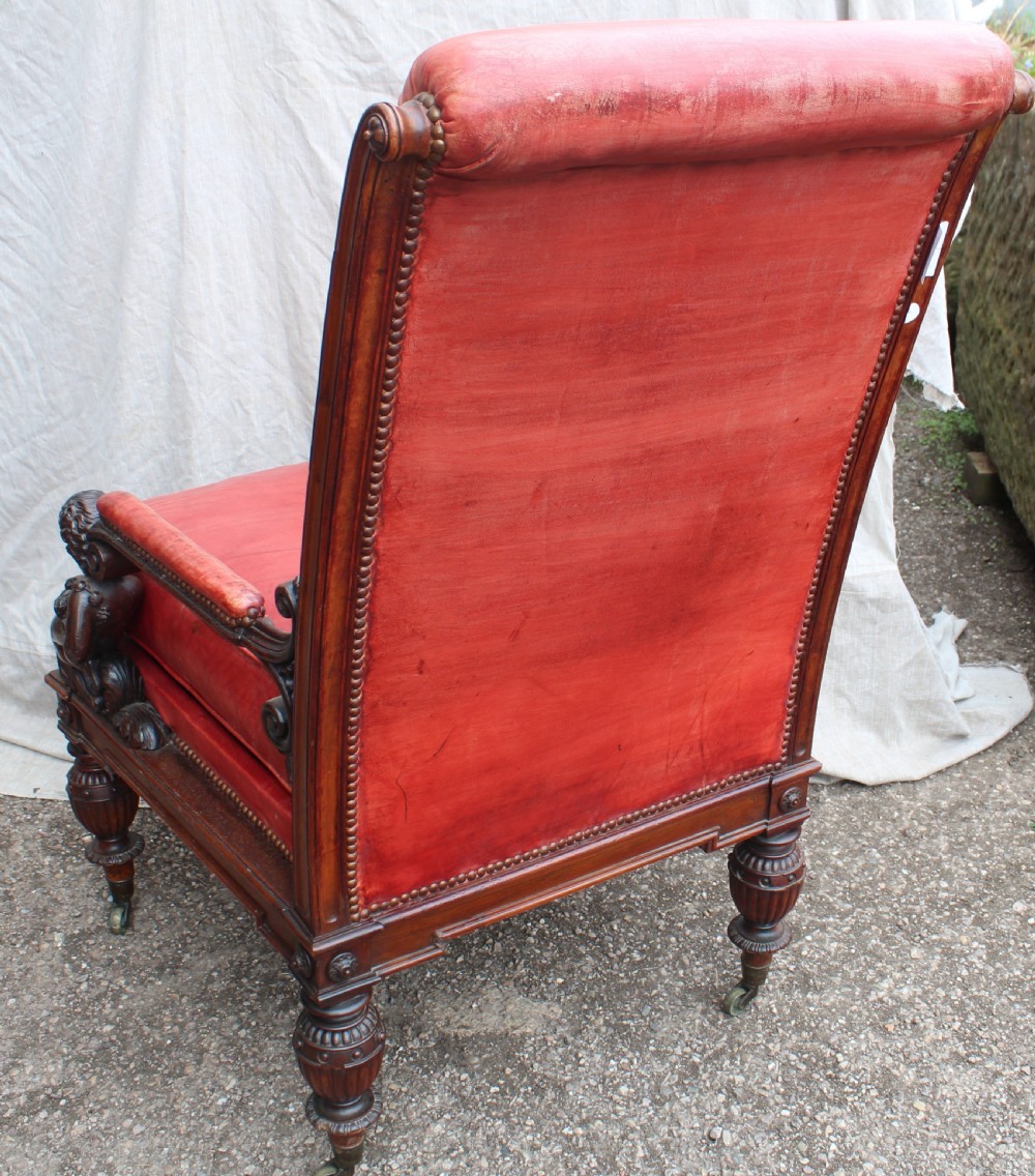 A pair of French armchairs upholstered in red leather with dark carved wood frames featuring cherub figures on the arm supports. View IV