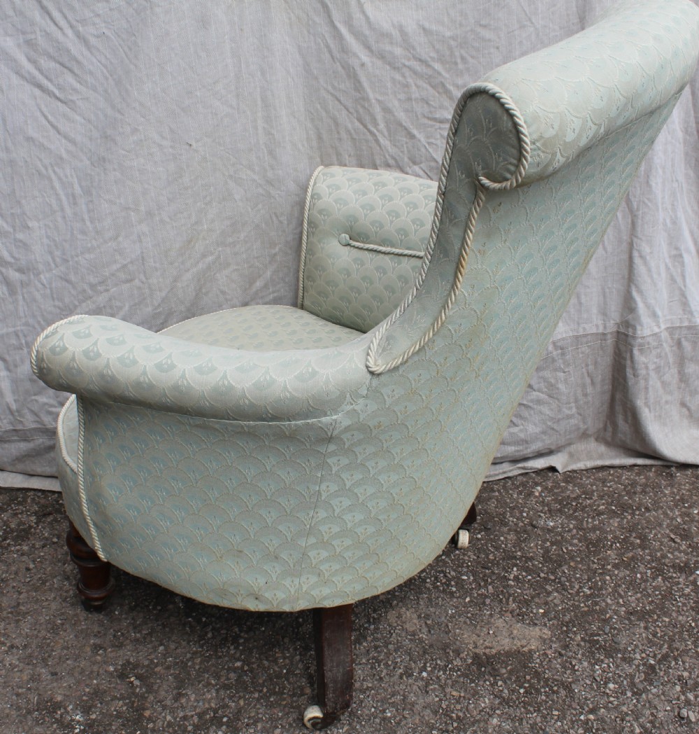 Victorian low upholstered armchair featuring pale duck egg blue patterned fabric with light rope piping and turned dark mahogany legs on ceramic castors. View III