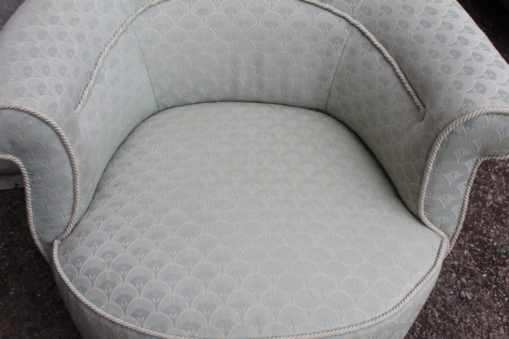 Victorian low upholstered armchair featuring pale duck egg blue patterned fabric with light rope piping and turned dark mahogany legs on ceramic castors. View V