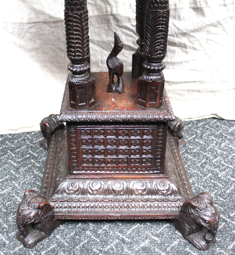 A dark brown hand-carved octagonal wooden occasional table featuring turned pillars and carved elephant head feet. View VI