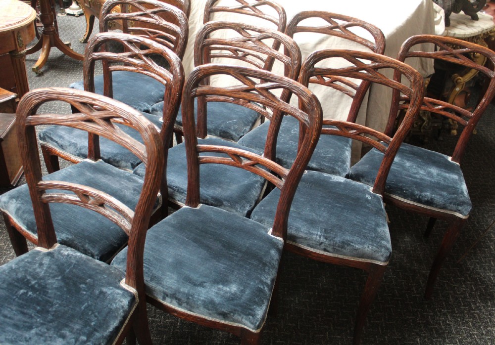 Set of ten dark brown faux bois dining chairs with rustic branch-like carved frame backrests and blue velvet upholstered seats. View III