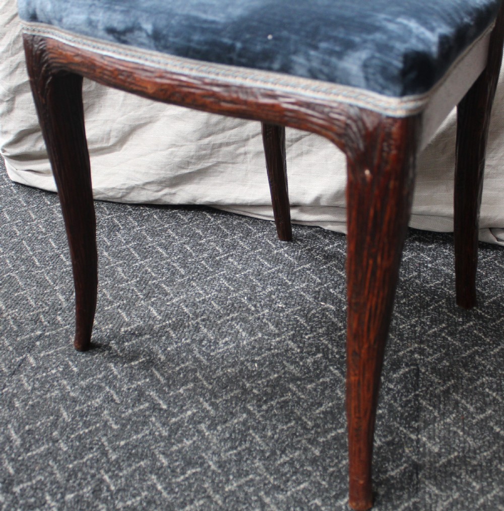 Set of ten dark brown faux bois dining chairs with rustic branch-like carved frame backrests and blue velvet upholstered seats. View VI