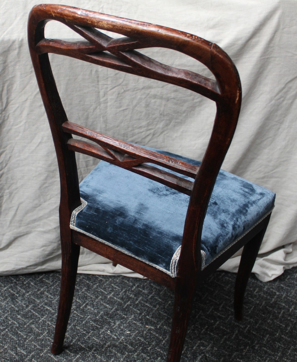 Set of ten dark brown faux bois dining chairs with rustic branch-like carved frame backrests and blue velvet upholstered seats. View VII