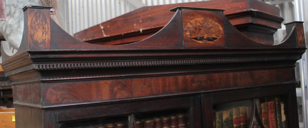 A dark mahogany Georgian secretaire bookcase featuring glazed upper doors with astragal tracery above a chest of four drawers with brass oval handles. View II