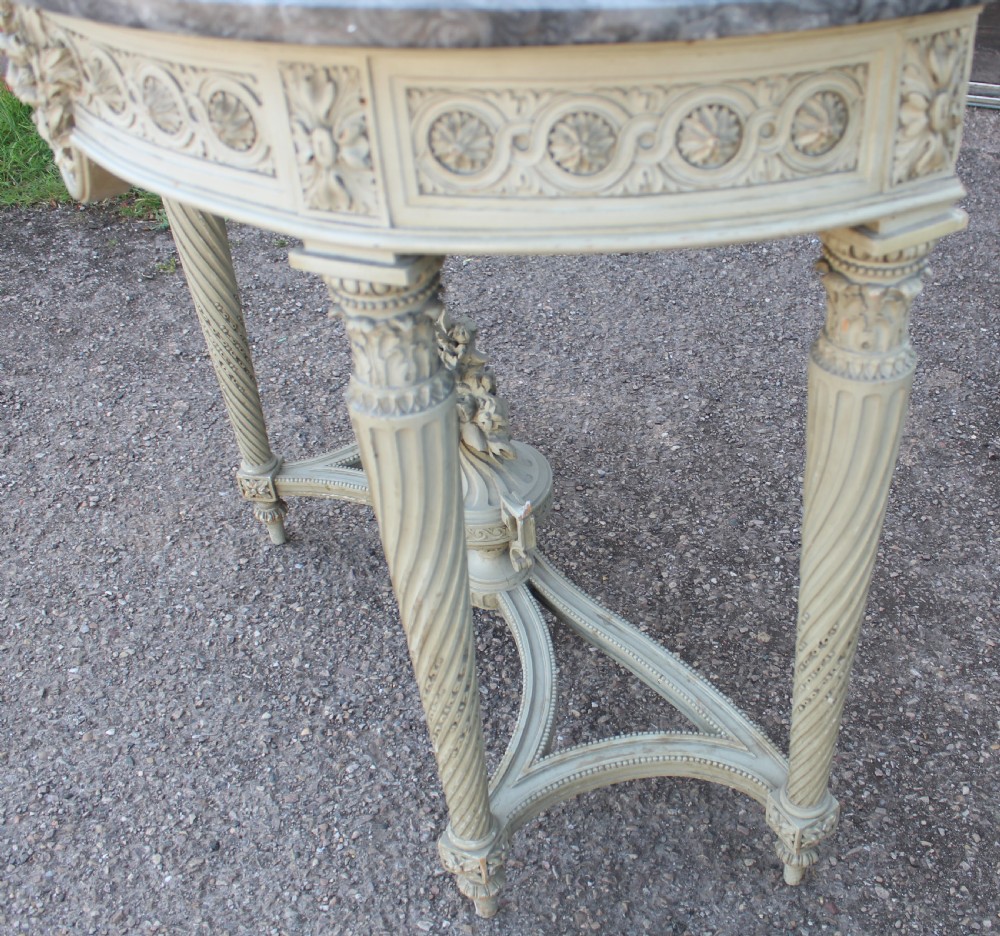 A Neoclassical French Louis XVI style demilune console table featuring a grey marble top, painted off-white carved apron, spiralled fluted legs, and a stretcher centred with a carved urn. View III