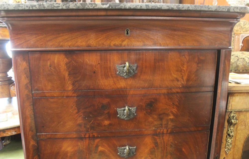 A tall 19th-century French flame mahogany semainier chest of drawers with a fitted grey marble top and ornamental brass handles. View IV