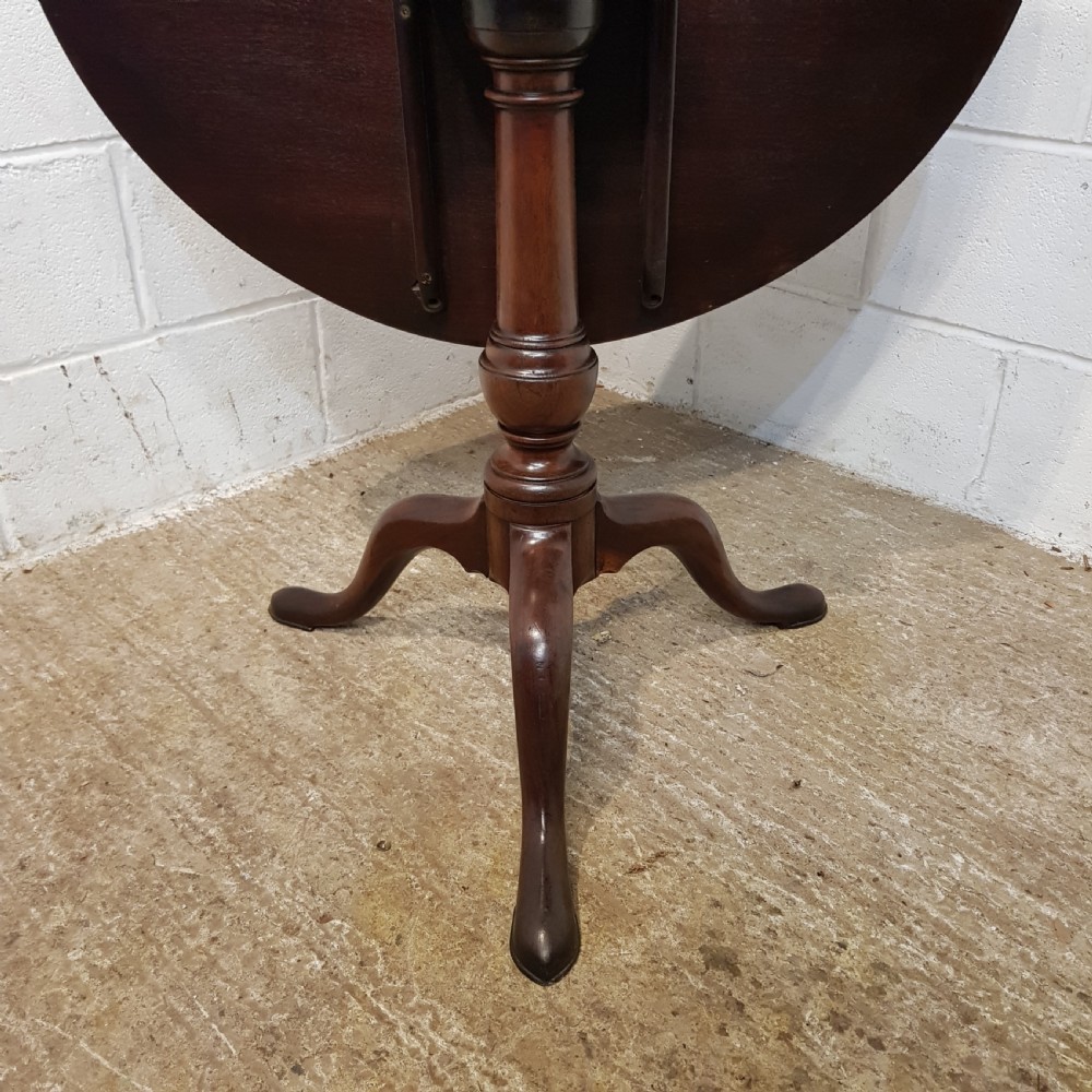 An 18th-century mahogany tilt-top table featuring a circular top displayed vertically above a turned central stem and a tripod base with pad feet. View II