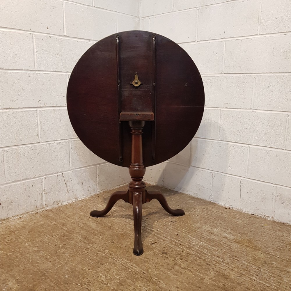 An 18th-century mahogany tilt-top table featuring a circular top displayed vertically above a turned central stem and a tripod base with pad feet. View III