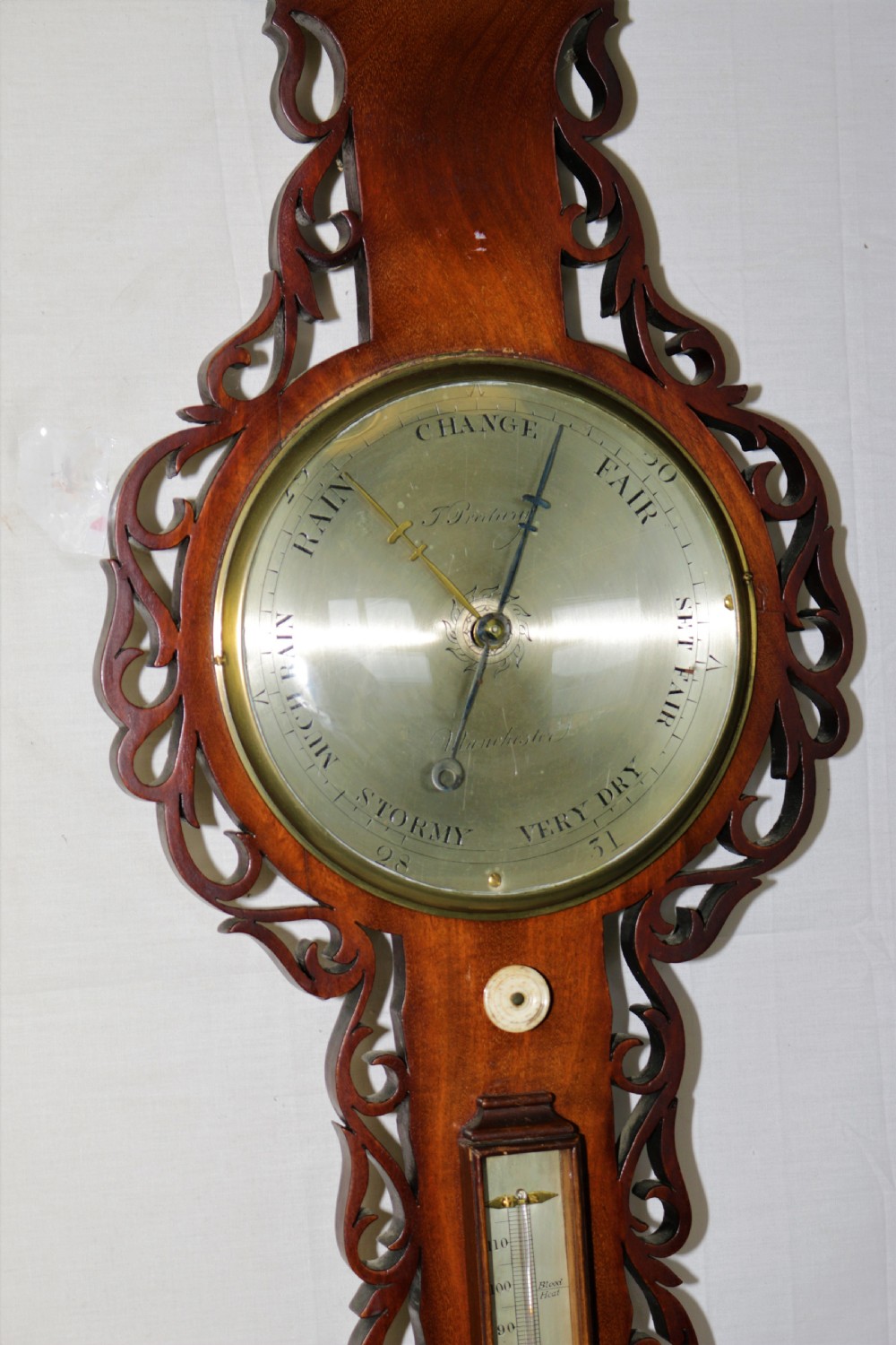 A Victorian mahogany hall stand featuring turned pegs, fretwork carving, an integrated barometer and thermometer, a white marble console surface, and lower drip trays. View VI