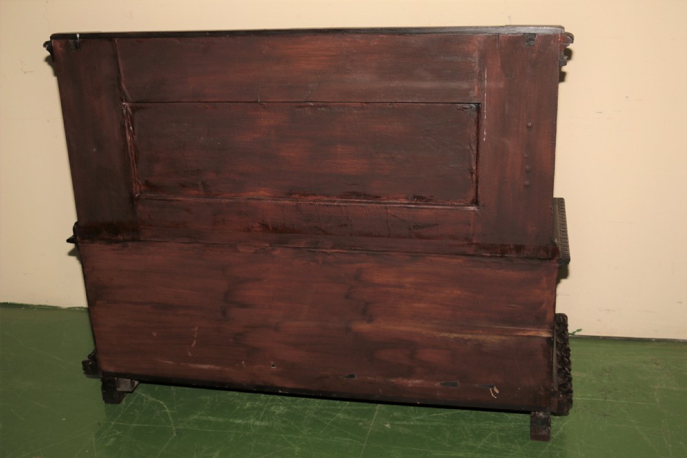 A dark carved walnut hall seat featuring high-relief carvings of mythical figures and floral scrollwork on the backrest and front storage panel. View XVIII
