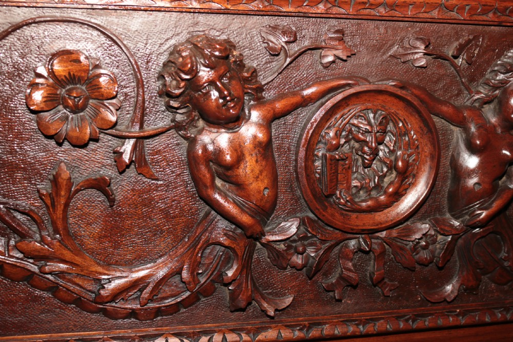 A dark carved walnut hall seat featuring high-relief carvings of mythical figures and floral scrollwork on the backrest and front storage panel. View XXI