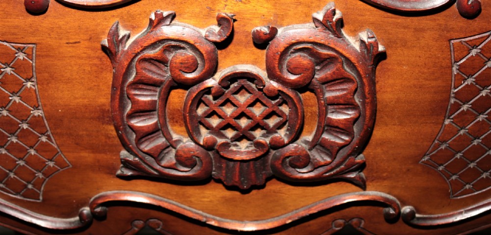 A dark brown carved mahogany display cabinet featuring glass doors and side panels, interior glass shelves, an ornate carved crest, and slender cabriole legs. View IV