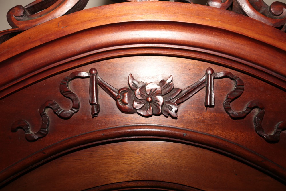 A dark brown carved mahogany display cabinet featuring glass doors and side panels, interior glass shelves, an ornate carved crest, and slender cabriole legs. View XIII