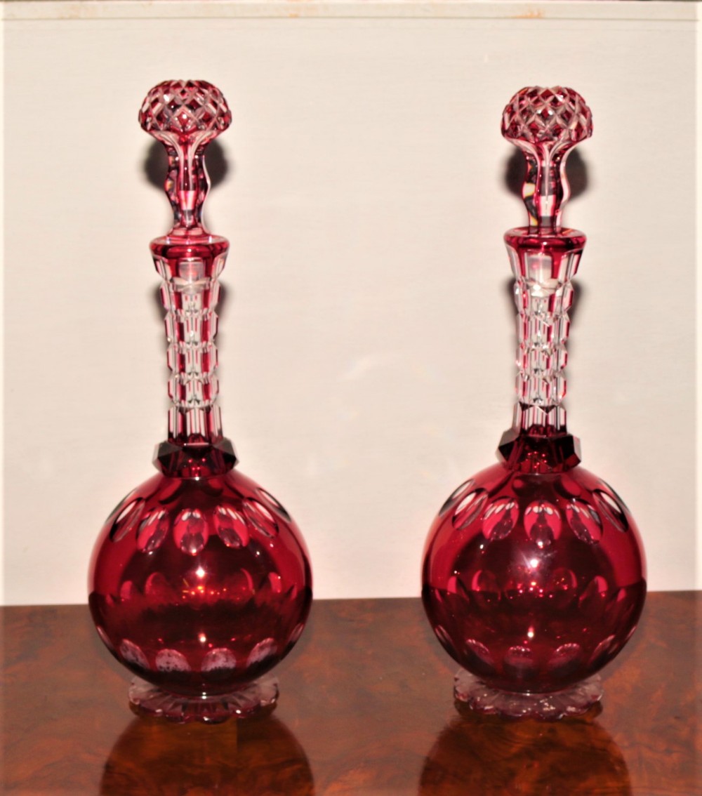 A pair of cranberry cut glass decanters.