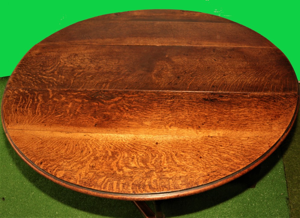 An antique oak gateleg dining table with turned baluster legs and drop-down semi-circular leaves shown in a folded position. View VI