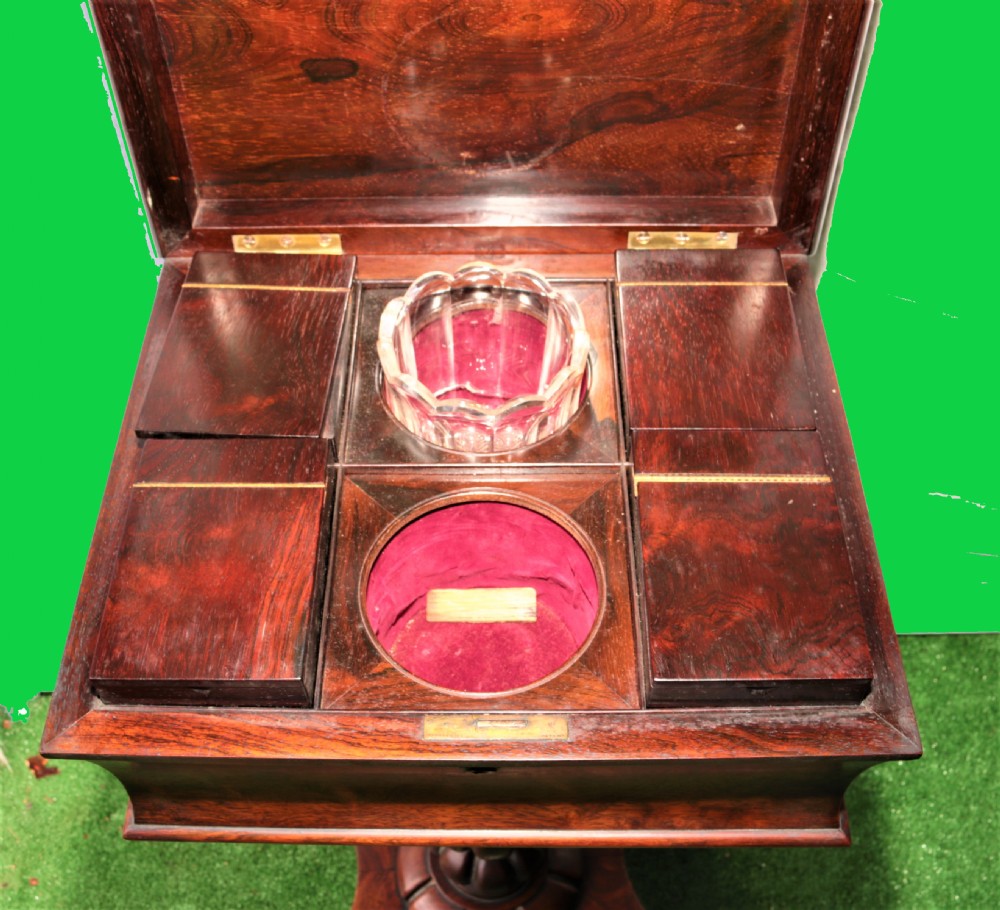 An open antique rosewood tea poy displaying internal wooden canisters, circular velvet-lined bowl apertures, a fluted pedestal stem, and a quadform base. View IV