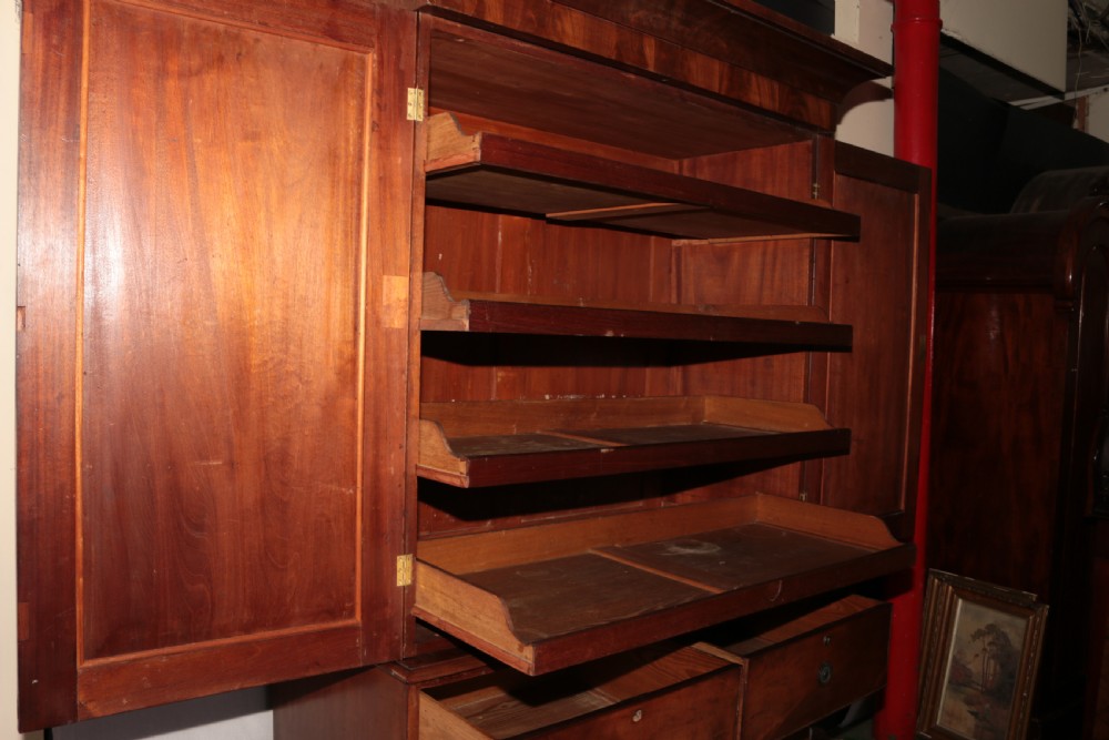 A Victorian flame mahogany linen press with a moulded cornice, arched double doors on the upper cabinet, and four drawers in the lower section. View VI