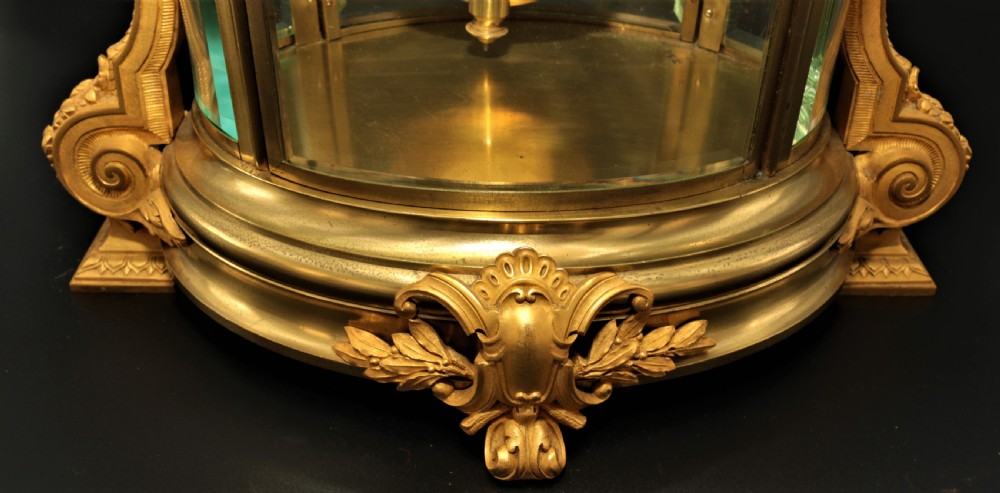 A French Louis XVI style gilt bronze four-glass mantel clock crowned with a decorated classical urn finial and a white enamelled dial. View XVI