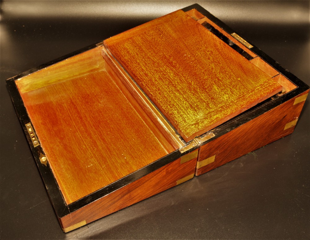A rectangular Victorian burr walnut writing box featuring brass straps, corner mounts, an engraved central cartouche, and an escutcheon keyhole. View II