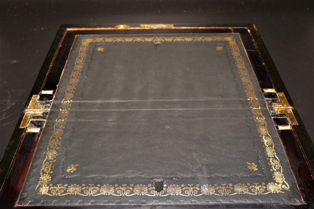 A rectangular Victorian burr walnut writing box featuring brass straps, corner mounts, an engraved central cartouche, and an escutcheon keyhole. View IX