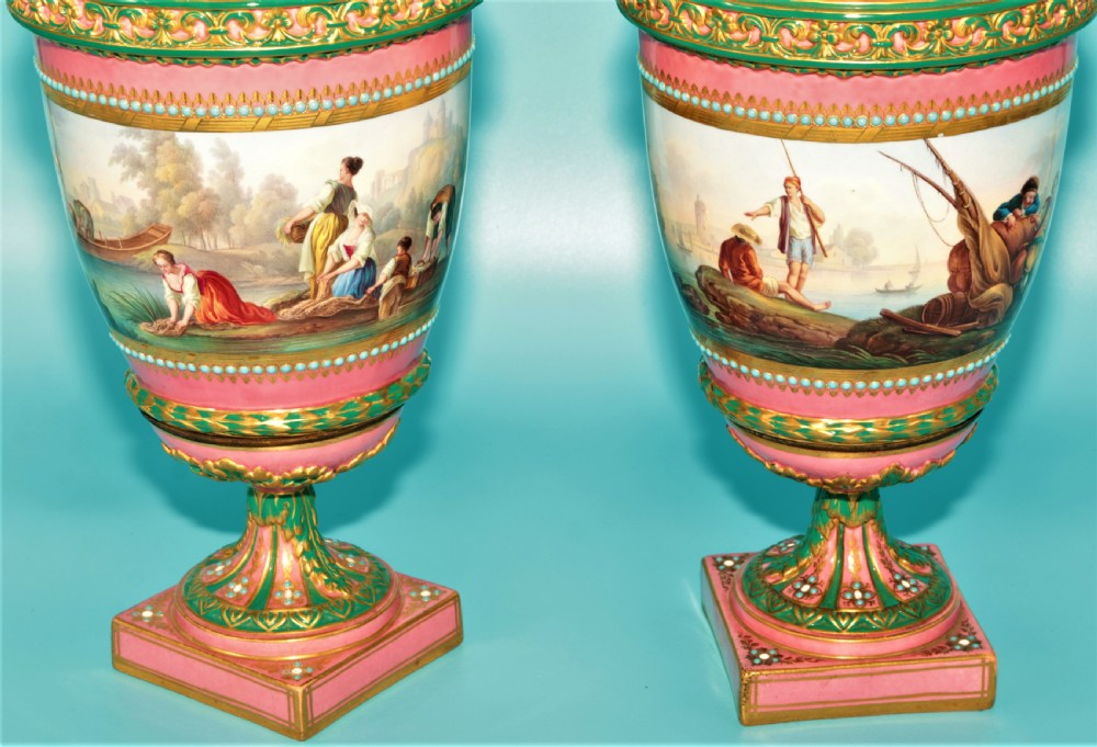 A pair of hand-painted pink porcelain urns featuring romantic pastoral figures, green detailing, intricate gilding, and square pedestal bases. View VII