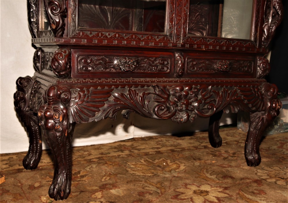 Intricately carved dark hardwood oriental display cabinet featuring high-relief dragon motifs, asymmetric glass-enclosed shelves, and floral back panels. View XI
