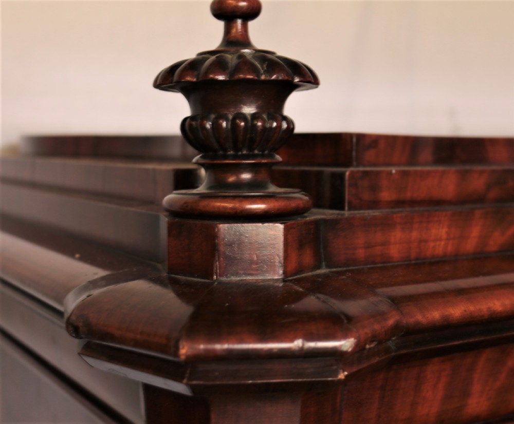 A Biedermeier flame mahogany fall-front bureau desk featuring twisted side columns, multiple drawers, brass keyhole escutcheons, and urn finials. View VII