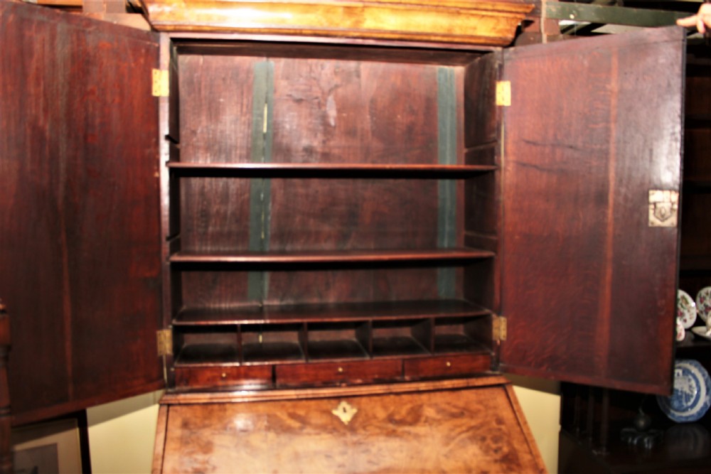 An early 18th-century George I burr walnut bureau bookcase featuring a twin-door upper cabinet above a slant-front writing bureau and drawers set on bun feet. View XIII