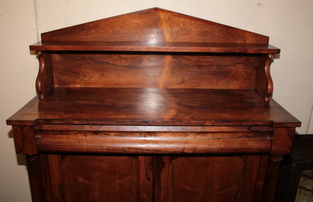 A Victorian rosewood chiffonier featuring a raised top display shelf, flame veneer cupboard doors, and turned side columns on a solid plinth base. View III