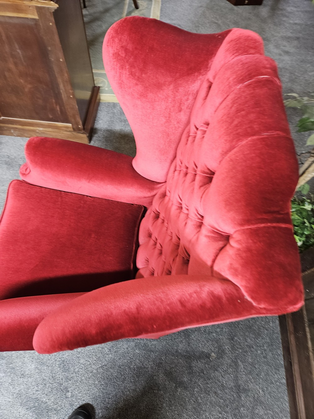 A Victorian high-back wing chair upholstered in red velvet with diamond button tufting and turned timber front legs on castors. View III