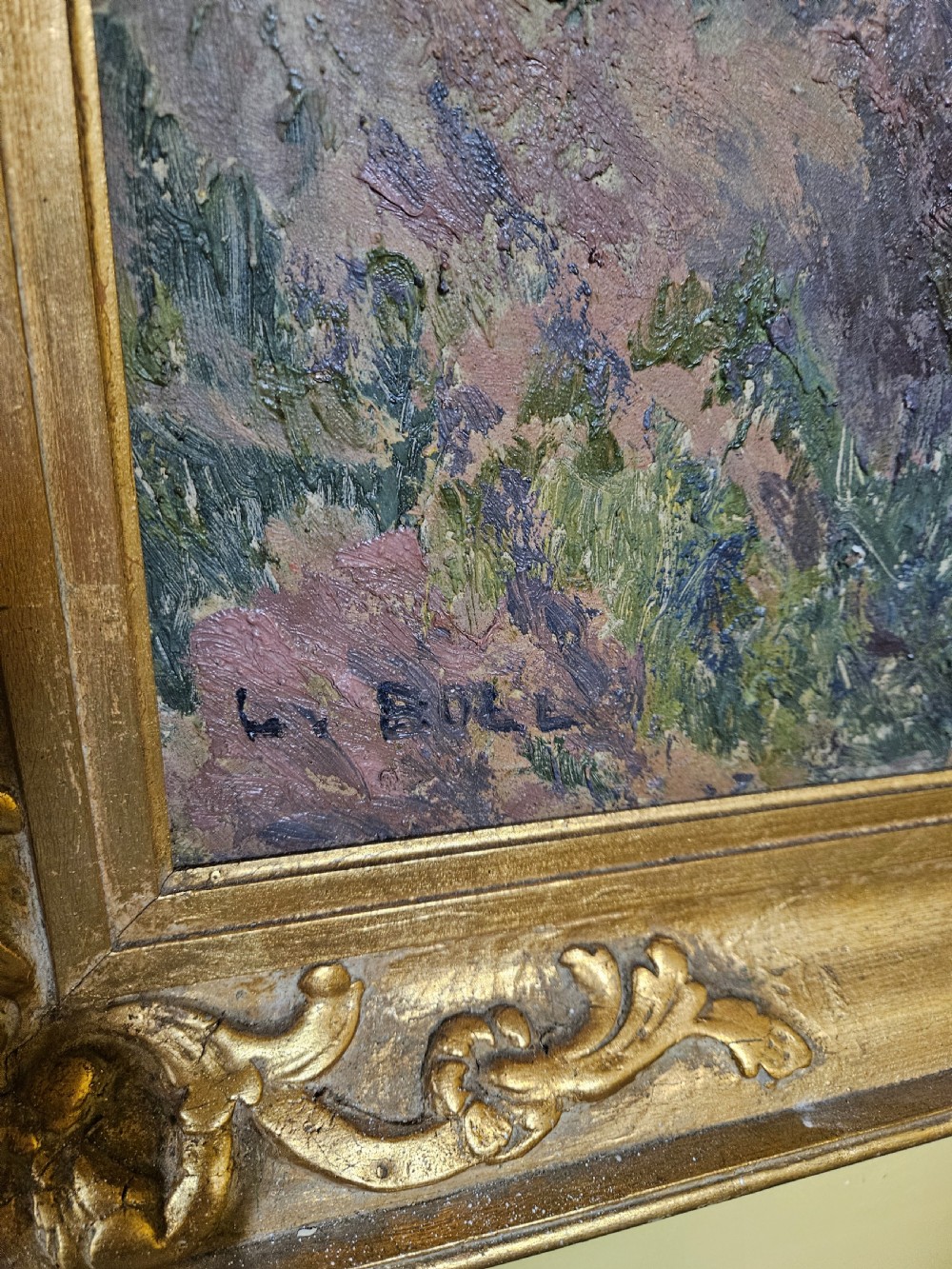 A large framed oil painting depicting a muddy countryside path lined with bare trees under an overcast sky, housed in an ornate gilt frame. View X