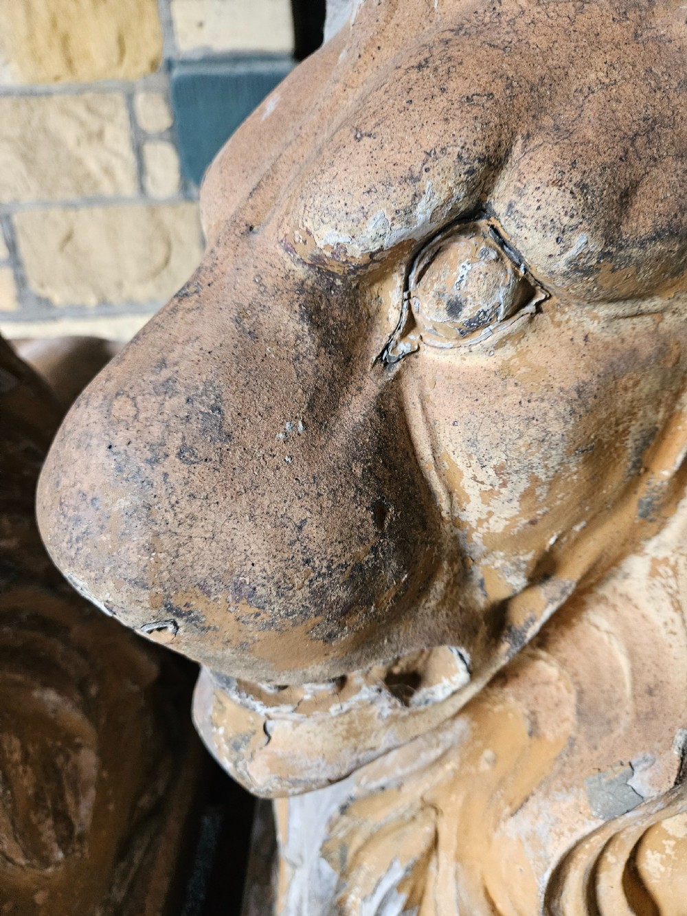 A pair of sculpted buff stone recumbent lion statues with detailed manes resting on integrated rectangular bases. View VI