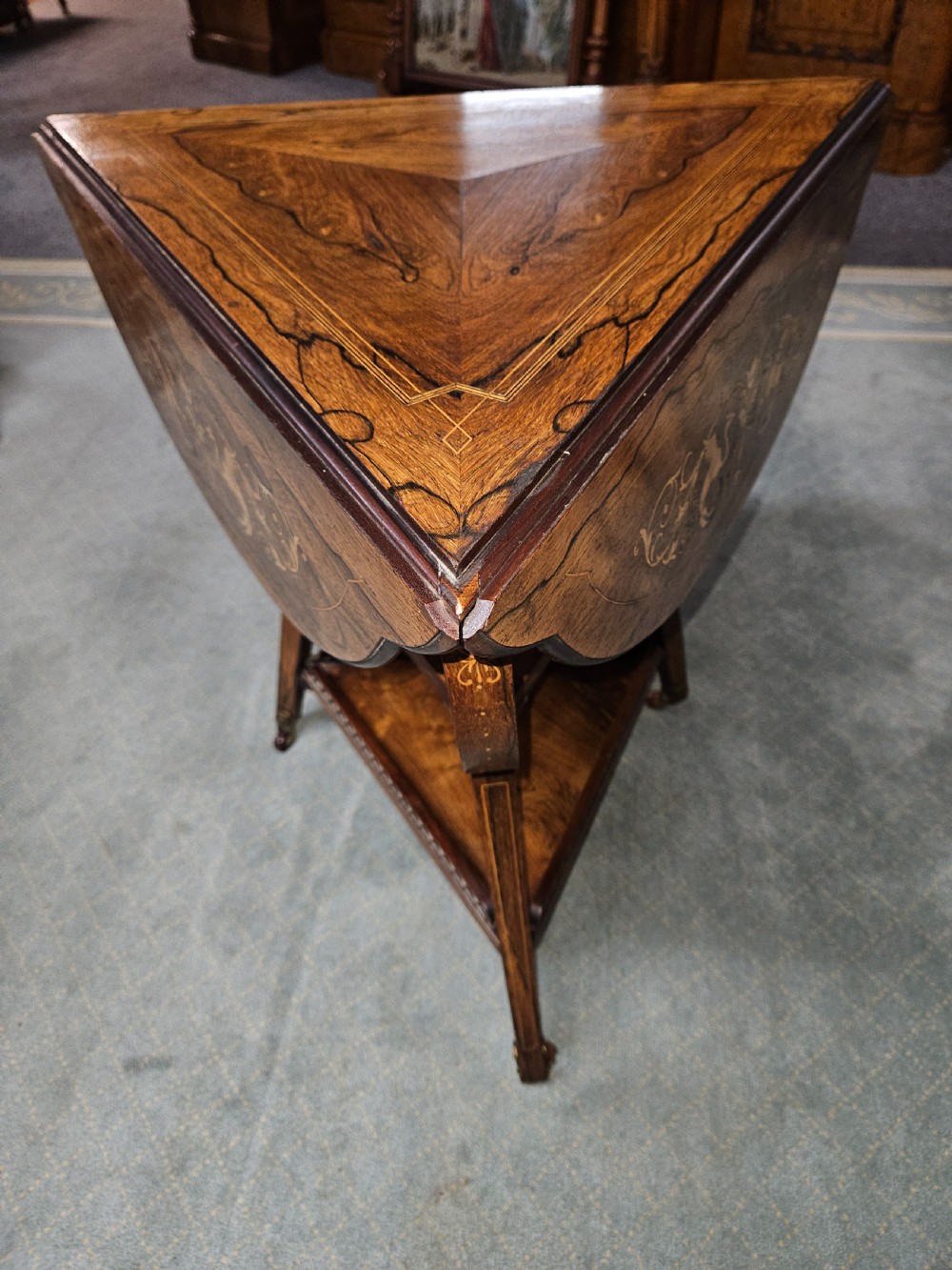 An inlaid rosewood drop-leaf table with extended circular scalloped leaves showing intricate floral marquetry and central geometric grain patterns. View III