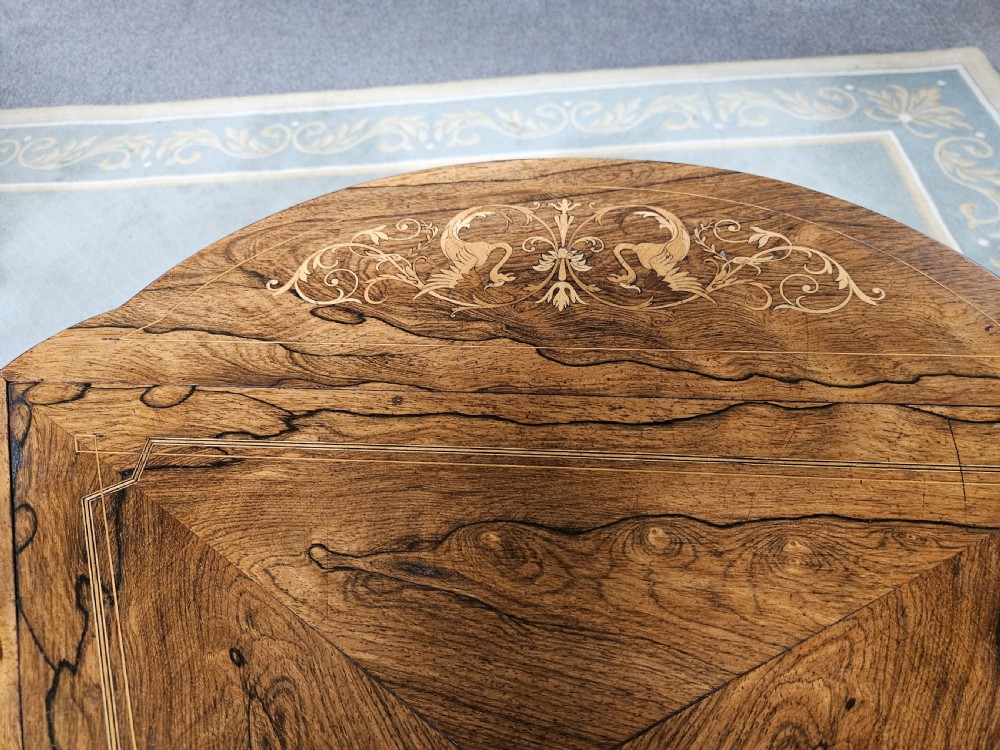 An inlaid rosewood drop-leaf table with extended circular scalloped leaves showing intricate floral marquetry and central geometric grain patterns. View XV