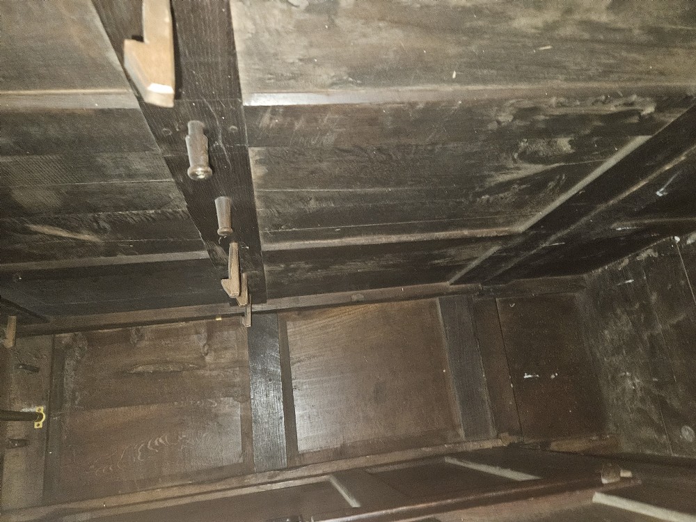 A large period dark oak livery cupboard featuring fielded arch-topped panel doors above a lower section fitted with drawers and brass hardware. View XXI