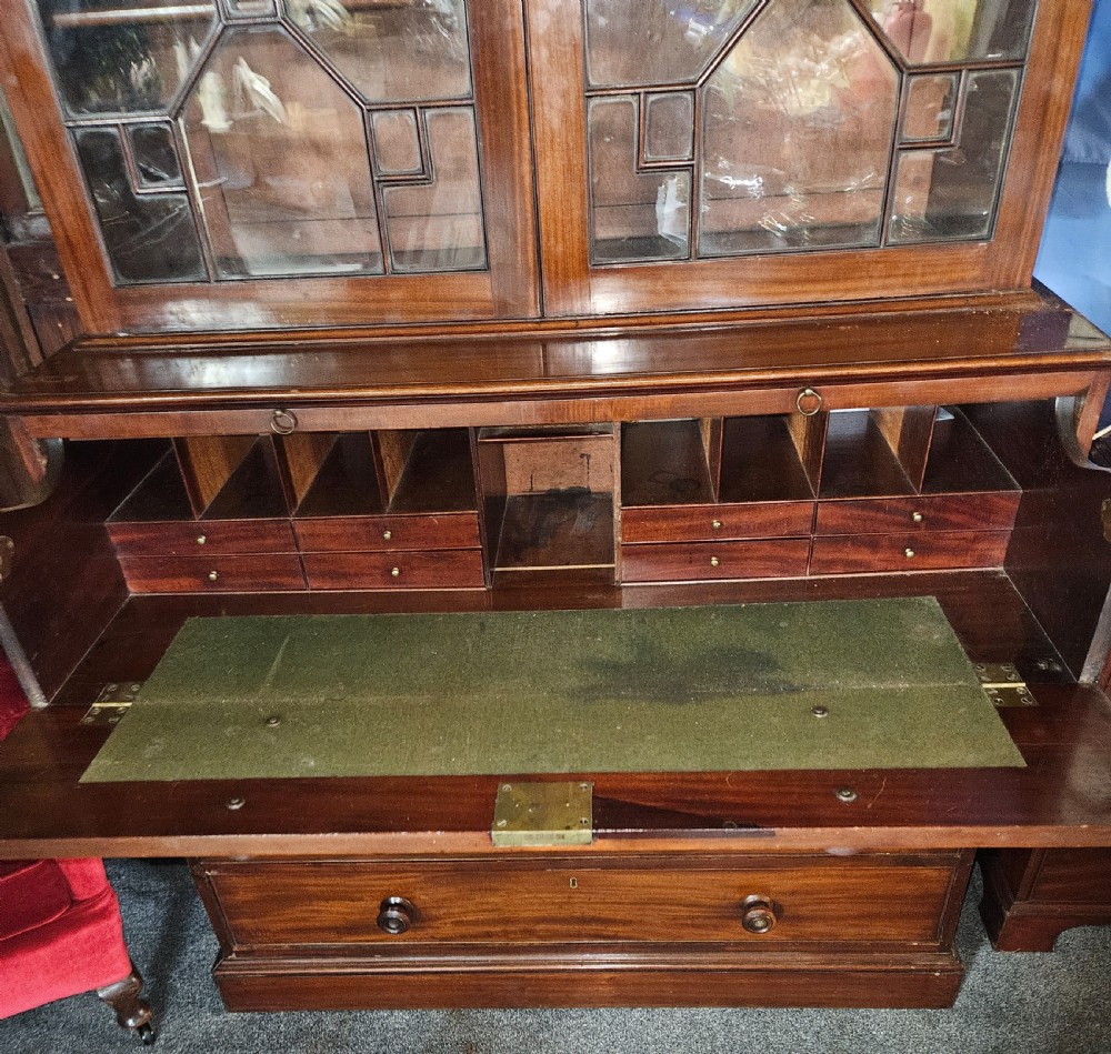 A Georgian mahogany secretary bookcase featuring upper astragal glazed double doors above a chest with six graduated drawers and turned knobs. View X