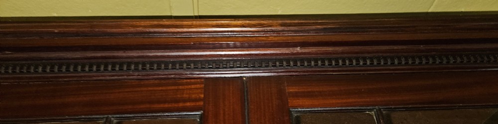A Georgian mahogany secretary bookcase featuring upper astragal glazed double doors above a chest with six graduated drawers and turned knobs. View XI