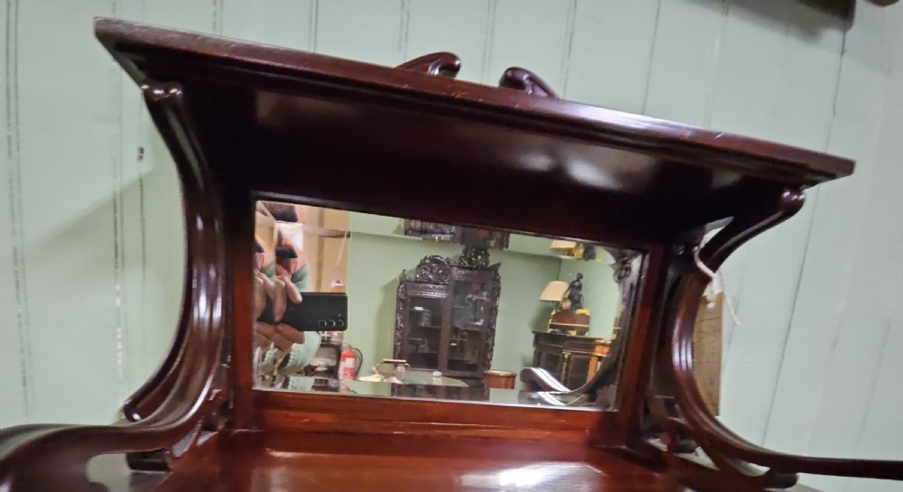 An Art Nouveau dark mahogany music cabinet featuring detailed wood marquetry, a pierced metal cartouche panel, and an upper mirrored gallery shelf. View VII