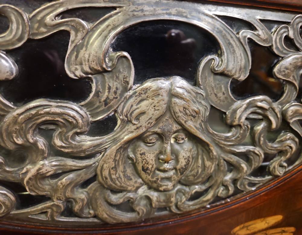 An Art Nouveau dark mahogany music cabinet featuring detailed wood marquetry, a pierced metal cartouche panel, and an upper mirrored gallery shelf. View XVIII