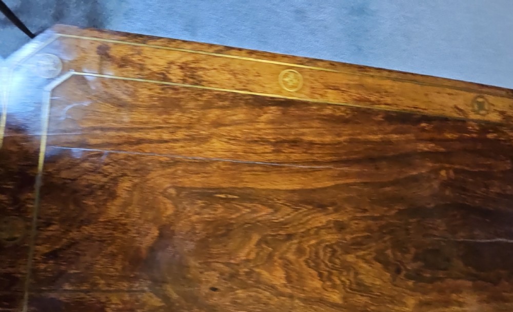 A Regency rosewood games table featuring brass inlay embellishments, a central pedestal, and splayed quadripartite legs with brass caps. View XIV