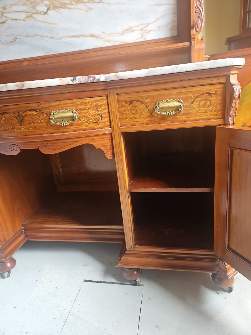 A satinwood inlaid washstand featuring a dark veined marble surface and splashback above three drawers and twin cupboard doors with inlaid urn motifs. View III
