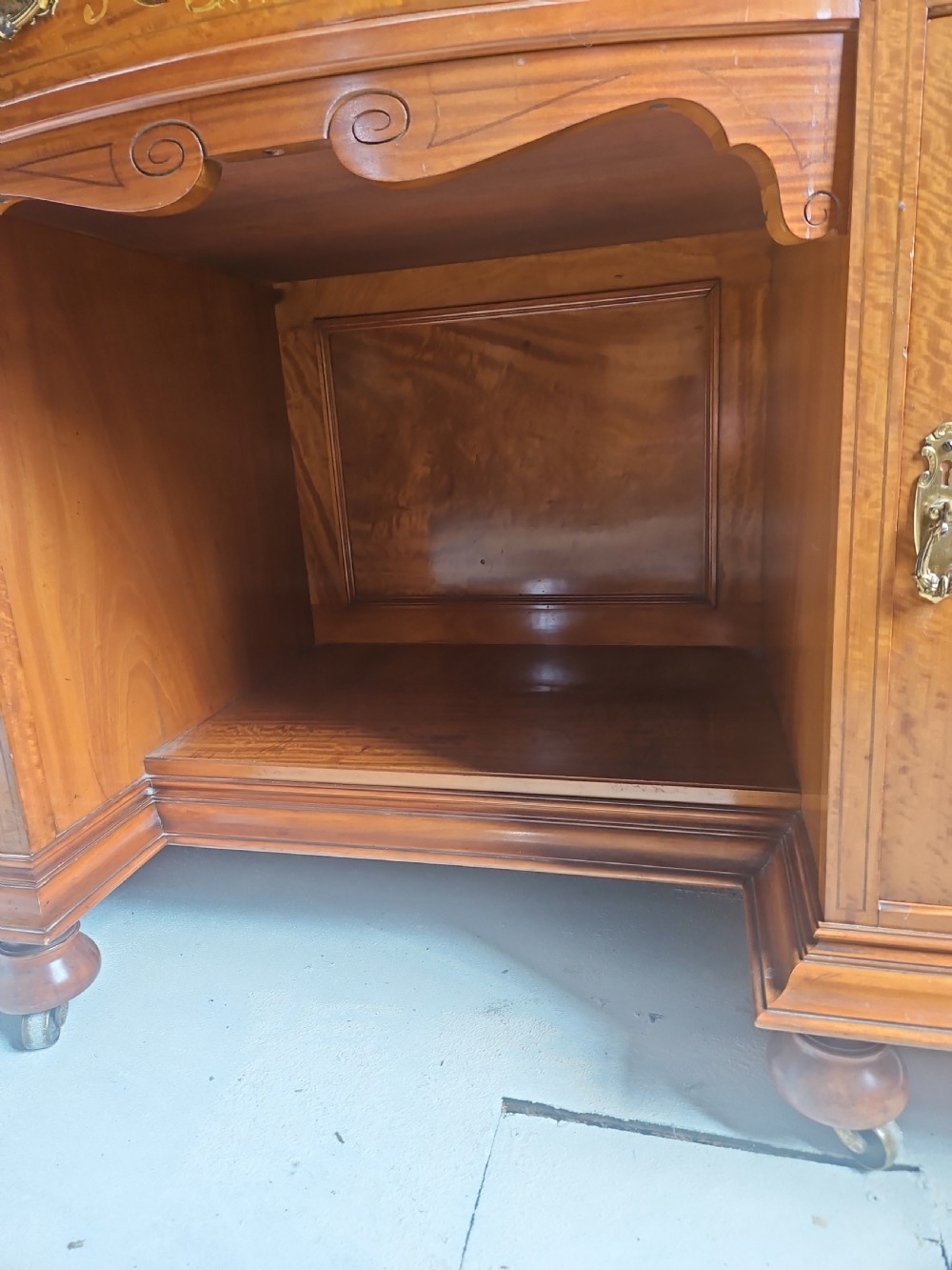A satinwood inlaid washstand featuring a dark veined marble surface and splashback above three drawers and twin cupboard doors with inlaid urn motifs. View VII