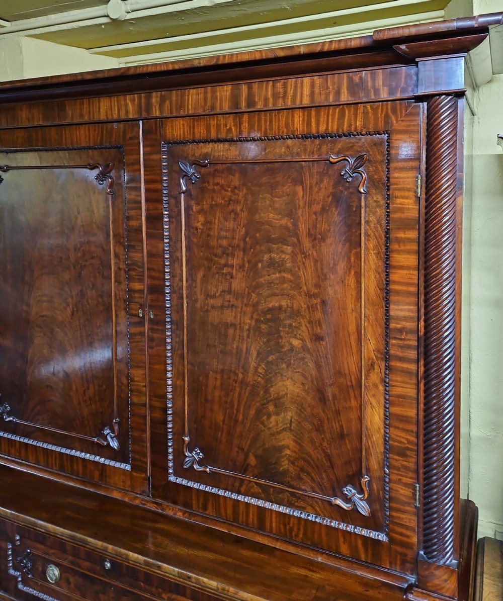 A William IV mahogany secretary bookcase featuring a two-door upper section, a central secretary drawer, and a lower kneehole flanked by cupboards with spirally turned columns. View II